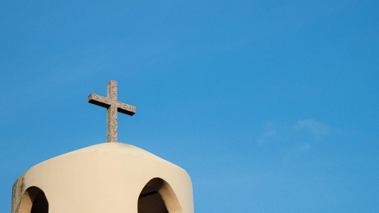 Cruz de piedra sobre el campanario de una iglesia, símbolo del matrimonio canónico y la nulidad eclesiástica
