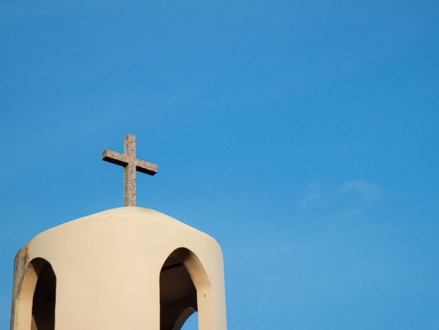 Cruz de piedra sobre el campanario de una iglesia, símbolo del matrimonio canónico y la nulidad eclesiástica