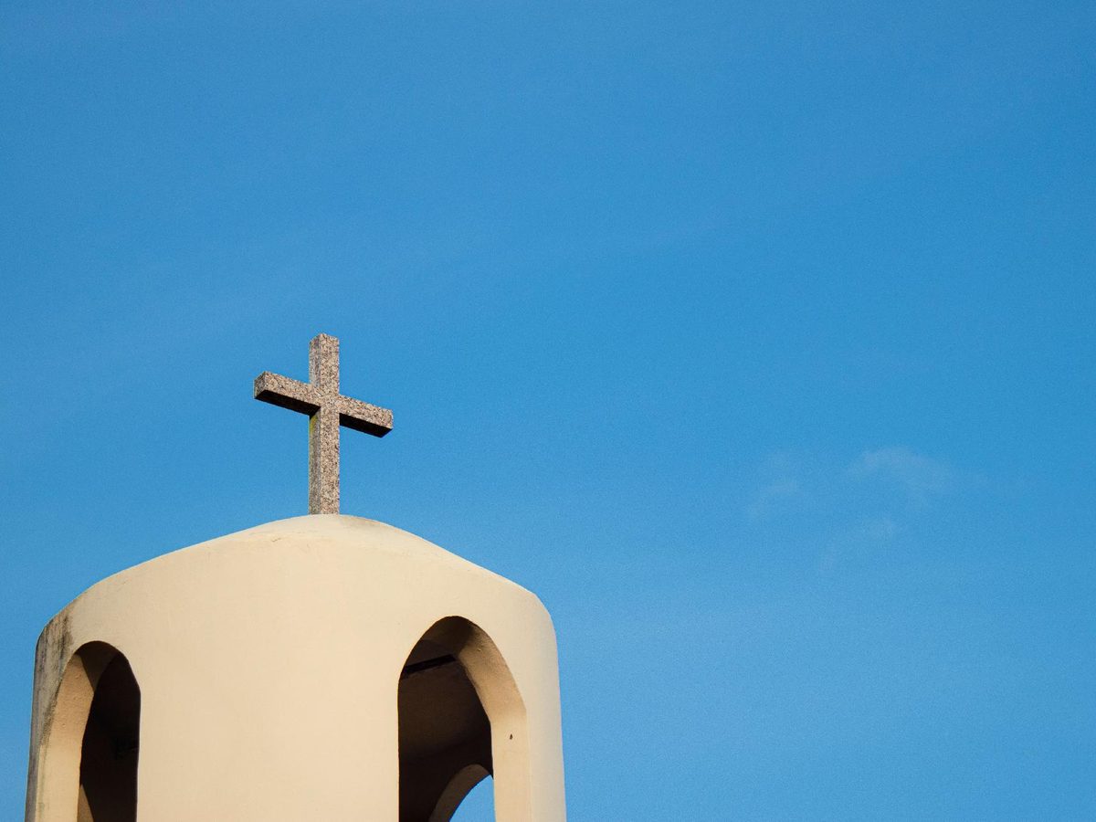 Cruz de piedra sobre el campanario de una iglesia, símbolo del matrimonio canónico y la nulidad eclesiástica
